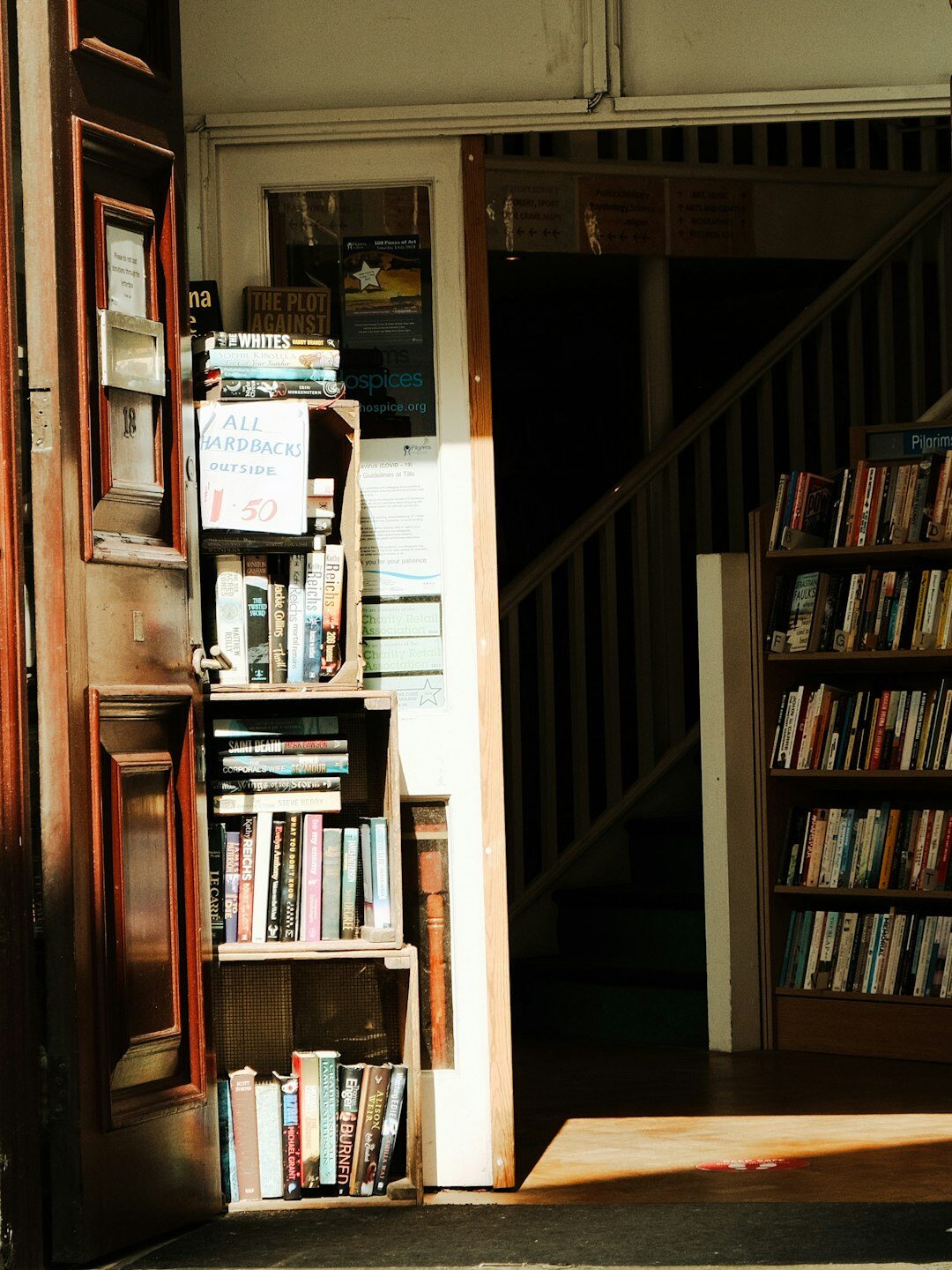 Tall wooden bookshelves filled with old books in a dim library